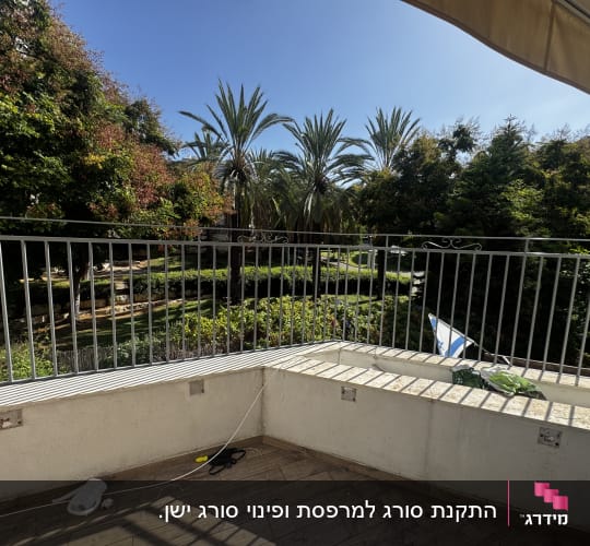 מעקה ברזל במרפסת עם נוף לעצים וגינה